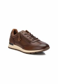 Zapatilla de cuero marrón con un perfil bajo, diseño de cordones, detalle de cremallera lateral, forro de ante marrón y suela de color claro.