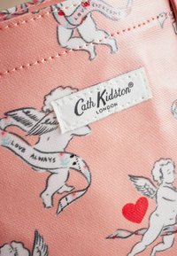 Rosa Stoff mit Engeln und Herzen, versehen mit einem dekorativen Banner mit der Aufschrift "LIEBE IMMER." Enthält ein weißes Markenetikett: "Cath Kidston® LONDON."