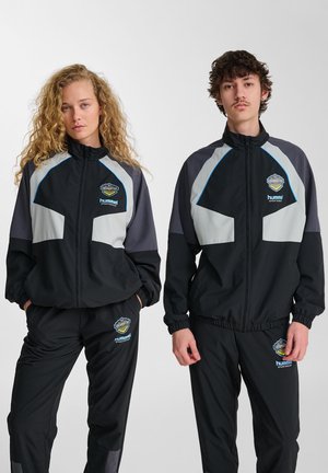 Svart och grå sportiga träningsdräkter med zippered jackor och elastiska byxor; med logotypdetaljer och färgblockerat mönster.