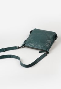 Borsa a tracolla in pelle verde acqua con finitura testurizzata, forma rettangolare, chiusura con zip e tracolla regolabile. Presenta dettagli in metallo nero.