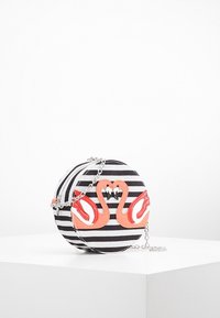 Pyöreä laukku, jossa on mustavalkoiset raidat, ja etupuolella on kaksi korallinväristä joutsenkuvaa, hopeaketjuolkaimet ja vetoketjullinen suljenta.