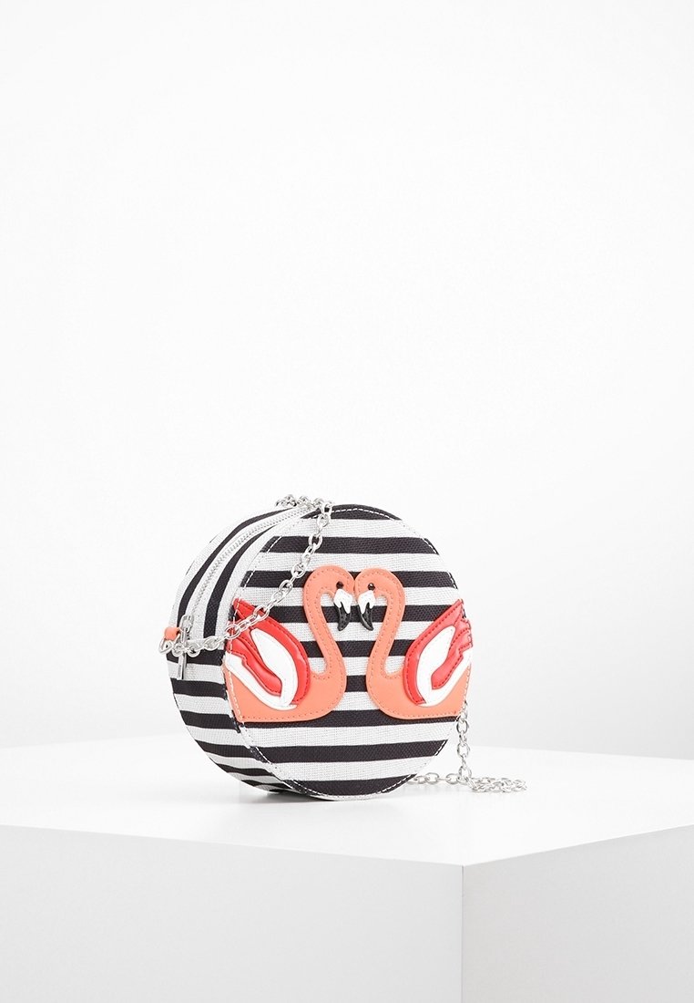 Pyöreä laukku, jossa on mustavalkoiset raidat, ja etupuolella on kaksi korallinväristä joutsenkuvaa, hopeaketjuolkaimet ja vetoketjullinen suljenta.