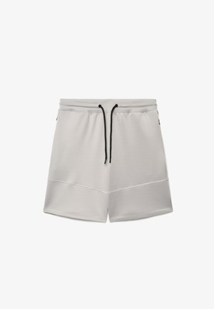 Pantaloncini casual grigio chiaro con vita a coulisse nera e dettaglio di cuciture sulle gambe, distesi su sfondo bianco.