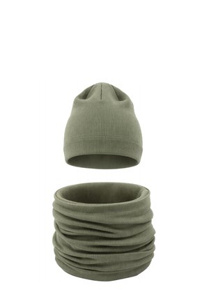 Zimowa czapka z prążkowanej tkaniny w kolorze oliwkowej zieleni oraz pasujący komin na szyję, prezentowane na białym tle.