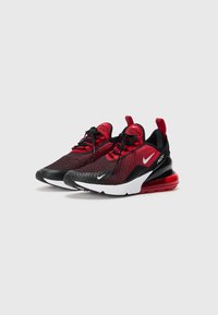Tênis Nike Air Max em malha preta e vermelha com sola branca. Apresenta uma unidade de ar visível no calcanhar, cadarços redondos e um cabedal com padrão.