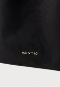 Svart läderväska med en slät textur, med den guldiga logotypen "VALENTINO" framträdande visad längst ner.