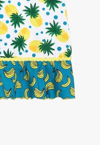 Vestito con parte superiore bianca decorata con ananas gialli e foglie verdi, pois blu, e fondo turchese arricciato con motivi di banane.