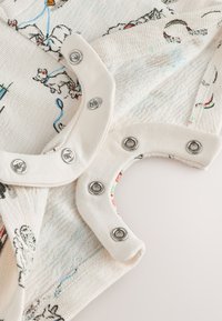 Kokvilnas bodijs ar fakturētu baltu audumu, uz kura ir daudzkrāsaina dzīvnieku apdruka. Kakla izgriezumā aizdares ar spraugām kontrastējošā audumā.