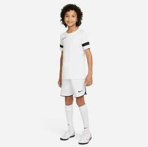 Witte sportshirt en shorts met zwarte accenten, met het Nike logo. Inclusief witte sokken en voetbalschoenen met rode details.