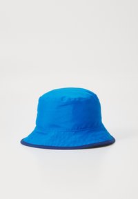 Ljusblå bucket-hatt i slät tyg med bred skärm. Nederkanten har en mörkblå accent.