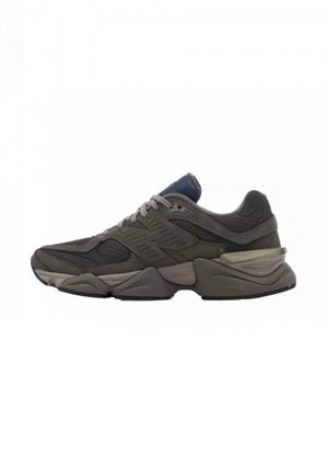 Scarpa sportiva da uomo in grigio scuro, caratterizzata da una combinazione di tessuti in rete e scamosciati, un colletto imbottito e una suola in gomma spessa.