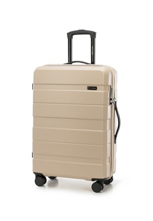 Beige hard-shell suitcase with horizontal ribbed texture, retractable black handle, side handle, and four black wheels for maneuverability.