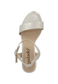 Sandalia de tiras en color beige claro con un acabado metálico suave, diseño de punta abierta y correa en el tobillo ajustable. Suela texturizada con branding.
