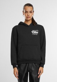 Black hoodie featuring a front pocket, drawstring hood, and white text graphic that reads "GOOD VIBES ONLY." Soft texture, casual design.