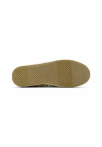 Shoe sole with a flat, textured surface, featuring a tan rubber material, round grip patterns, and a smooth rounded toe.