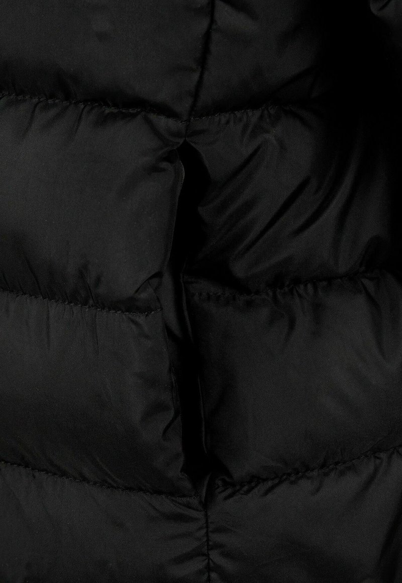 Giacca a vento nera con dettagli che presentano una texture trapuntata, sezioni imbottite e tessuto liscio, che mette in evidenza un design pulito e minimalista.