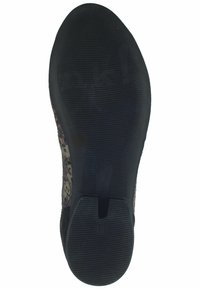 Suela de goma negra con agarre texturizado, que presenta un upper de tela floral en tonos de rosa y beige, y una cinta en el talón.