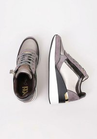 Zapatillas gris con una mezcla de materiales de ante y cuero, con una suela blanca y negra, cordones y acentos dorados en el lateral.