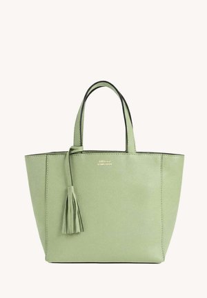 Sac cabas en cuir vert clair avec deux anses et un pompon décoratif suspendu près du bord supérieur.