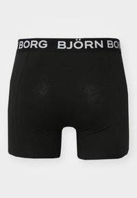 Black boxer shorts with a soft elastic waistband featuring the white text "BJÖRN BORG." The material is smooth, with a fitted design.