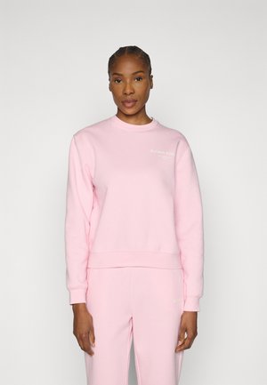 Ανοιχτό ροζ φούτερ με στρογγυλή λαιμόκοψη, ριμπ μανσέτες και τελείωμα. Διαθέτει κείμενο με το όνομα της μάρκας στο στήθος. Απαλό, καθημερινό ύφασμα.