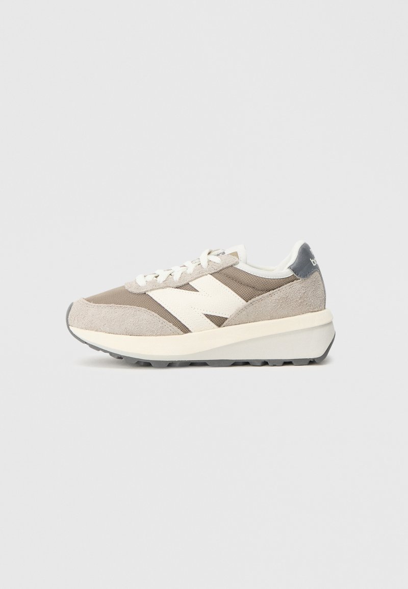Graue Wildleder- und Mesh-Sneaker mit einem weißen Logo und weißen Schnürsenkeln. Dicke weiße Zwischensohle, Gummilaufsohle und kontrastierende Fersenelement.