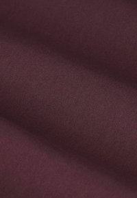 Bordeauxrode stof met een glad, gestructureerd oppervlak. Licht rekbare weving en een uniforme kleur over het geheel. Geschikt voor diverse textieltoepassingen.