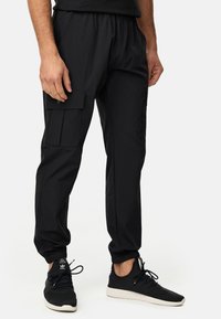 Zwarte cargobroek met een elastische tailleband, taps toelopende manchetten, zijzakken en een slank, lichtgewicht materiaal. Geschikt voor casual gebruik.