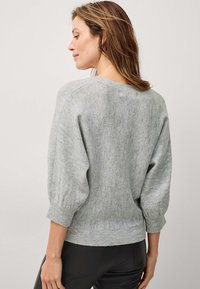 Pull en tricot gris avec des manches trois-quarts, des poignets et un ourlet côtelés, texture douce et coupe décontractée. Vue de dos montrant un léger design d'épaule tombante.