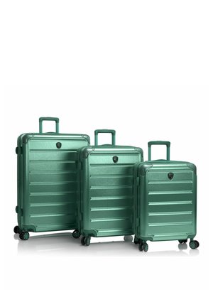 Tre valigie rigide verdi annidate con manici telescopici e quattro ruote girevoli ciascuna, disposte per dimensione dalla più grande alla più piccola.