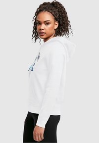 Weißer Hoodie mit einer Fronttasche, Kordelzugkapuze und einem farbenfrohen grafischen Design auf der Vorderseite. Glatte Stofftextur und reguläre Passform.