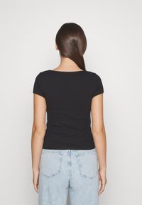 T-shirt nero a maniche corte con scollatura rotonda, realizzato in un materiale elasticizzato. Il retro presenta un design aderente e una superficie liscia.