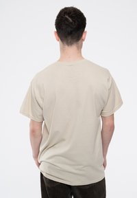 Beige cotton t-shirt with short sleeves, a crew neckline, and a relaxed fit. Plain design, displayed from the back.