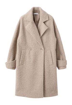 Manteau en laine beige à double boutonnage, avec larges revers, poches latérales et poignets retroussés sur manches longues.