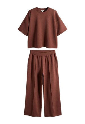 Braunes kurzärmeliges, lässiges Oberteil kombiniert mit hoch taillierten, weit geschnittenen Hosen aus dem gleichen Stoff und in der gleichen Farbe.