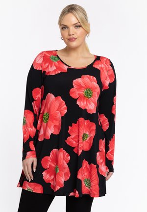 Tunique noire avec de grands imprimés floraux rouges, manches longues et encolure ronde. Le tissu a une texture lisse avec un léger elastique.
