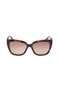 Lunettes de soleil écaille de tortue marron avec une forme œil de chat, verres dégradés et accents de branches noires élégants. Conçues pour une apparence audacieuse.