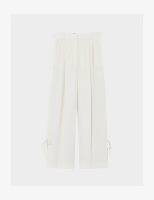 Kreemjad laiade sääreosadega püksid volditud voldide, vööaasade, küljetaskute ja äärtesse kinnitatavate nööriga reguleeritava laiusega.