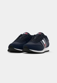 Scarpe da atletica blu navy con design con lacci, realizzate in materiali scamosciati e in rete, con suola bianca e accenti a strisce rosse e bianche sui lati.