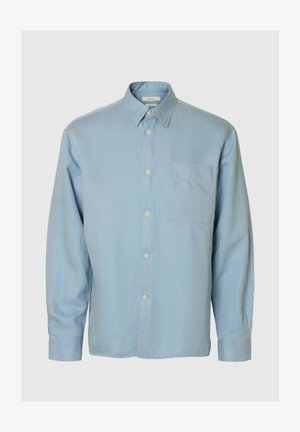 Vaaleansininen pitkähihainen nappipaita rintataskulla ja klassisella kauluksella, esillä yksiväristä taustaa vasten.