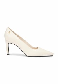 Kremowy szpilka z ostrym noskiem i małym złotym emblematem z logo w pobliżu pięty, na białym tle.