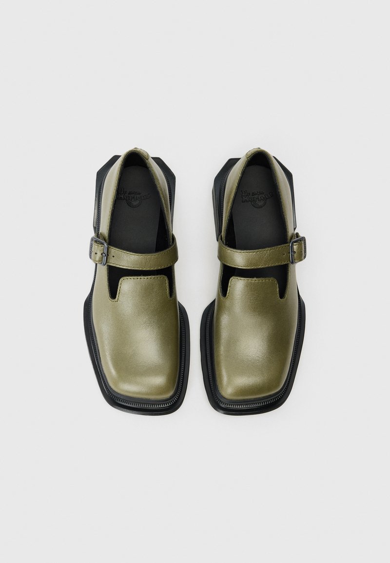 Olivgrüne Leder-Schuhe mit runder Zehenform, freiliegenden Seiten und einer schwarzen Gummisohle. Sie verfügen über einen vorderen Riemen mit einer Metallschnalle.