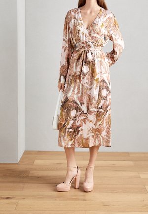 Long-sleeved, wrap dress in pink and brown marbled pattern, featuring a belted waist. Paired with light pink platform heels.