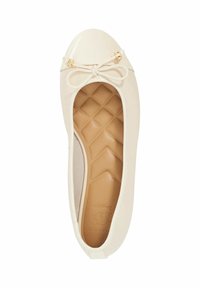 Beige patent leather ballet flat with a rounded toe, small bow detail at the front, and a textured insole featuring a diamond pattern.