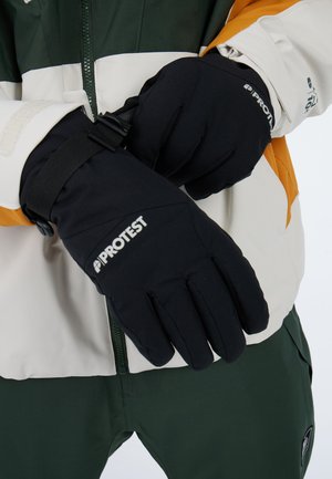 Zwarte handschoenen met een zachte textuur en een stevige riem; het logo "PROTEST" is prominent op de pols afgebeeld; gedragen met een meerkleurige jas.