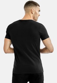 Svart kortärmad t-shirt med rundad halsringning, tillverkad av slät tyg. Baksidan har en enkel och ren design utan utsmyckningar.