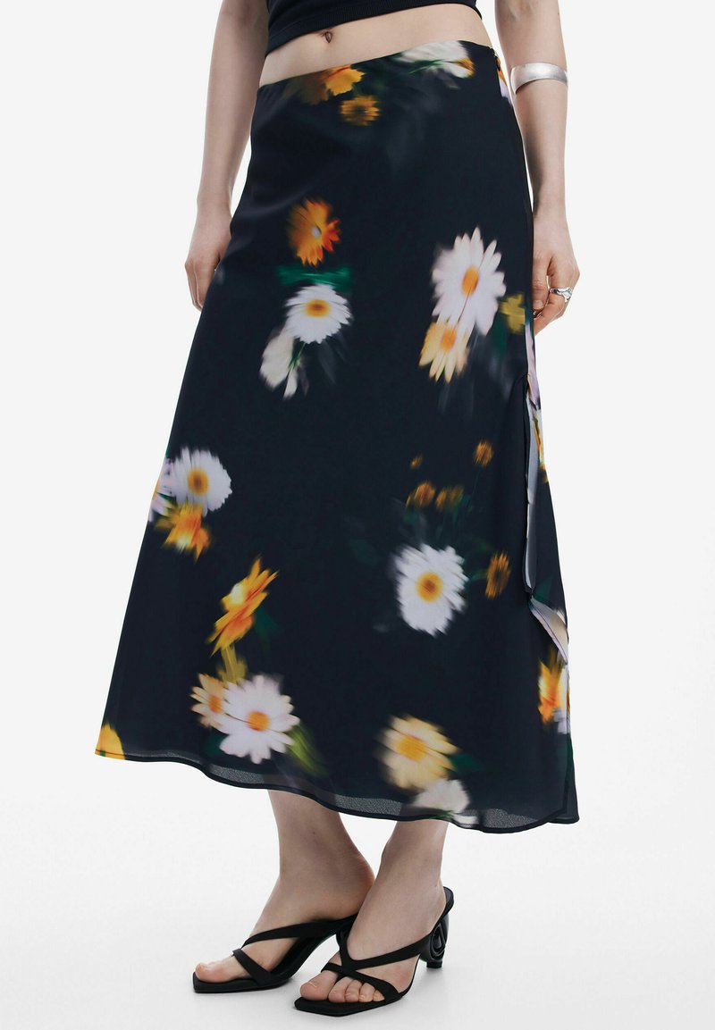 Svævende sort nederdel med gul og hvid marguerit-blomster mønster, lavet af letvægtsstof. Har en sidelæg og en glat tekstur.