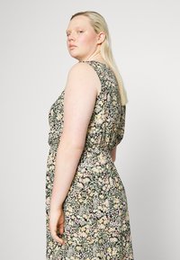 Vestido floral com fundo preto, apresenta flores em tons pastéis, design sem mangas, cintura ajustada e tecido suave e texturizado.