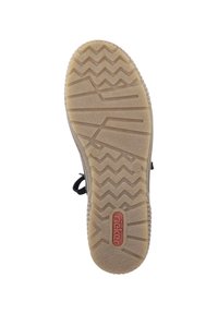 Semelle de chaussure en caoutchouc avec un motif de gomme en zigzag, couleur beige, et un logo rouge au centre. Présente une surface texturée et une conception durable.