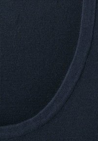 Tejido de color azul marino con relieve y una textura suave, con un escote redondo y costuras visibles a lo largo del borde.